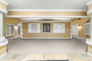 Empty room with light carpet, a textured ceiling, and crown molding