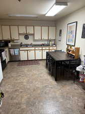 Two tone kitchen featuring dual tone cabinets and black appliances
