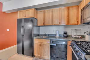 Kitchen featuring black appliances and light wood finish cabinetry