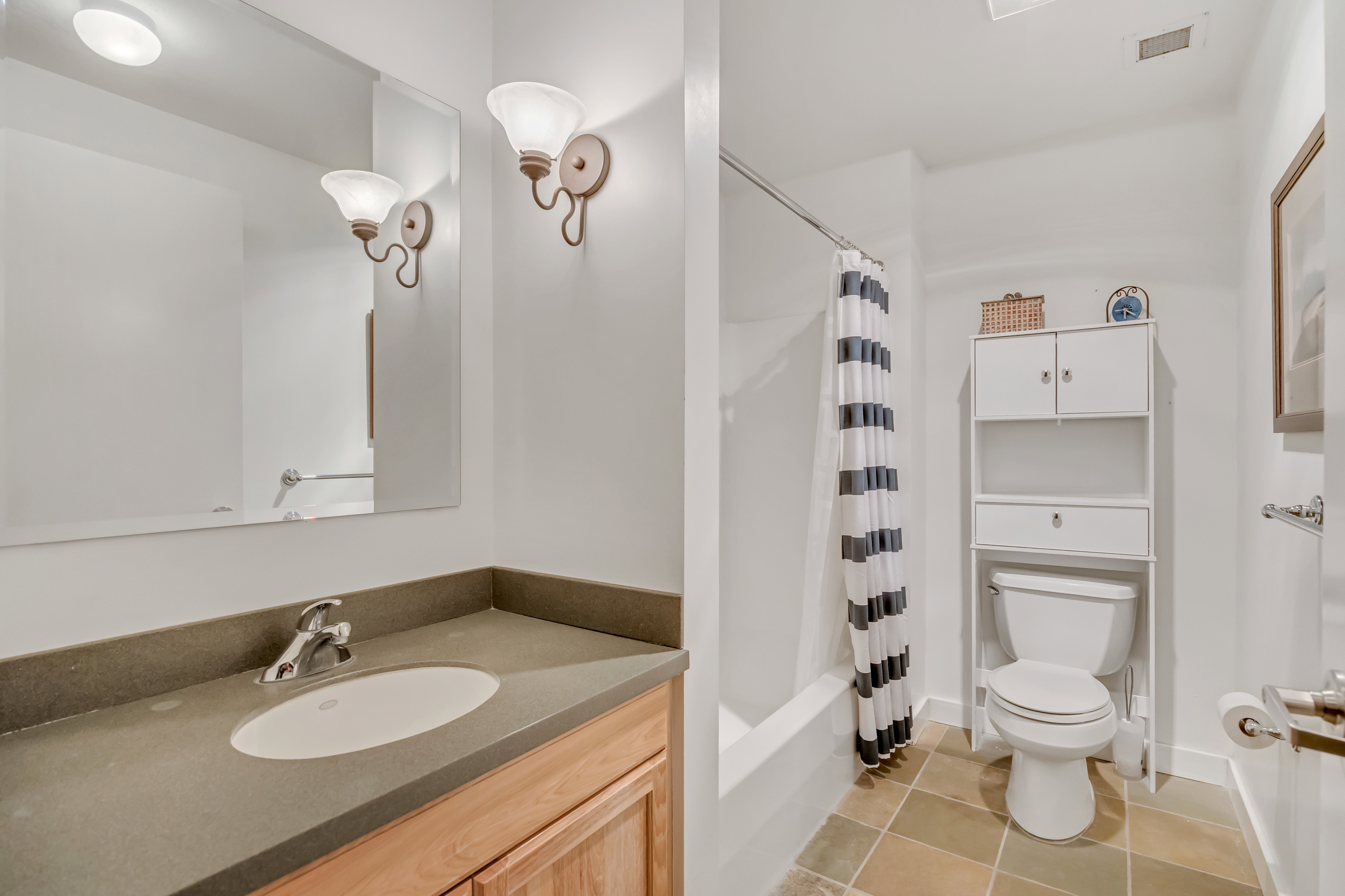 Bathroom with vanity, shower / bathtub combination with curtain, and light tile patterned floors