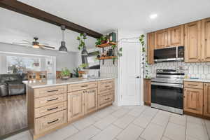 Kitchen with a peninsula, stainless steel appliances, light stone granite counters, backsplash, and open floor plan