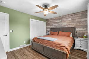 Bedroom featuring an accent wall, LVP floors, a closet, and ceiling fan