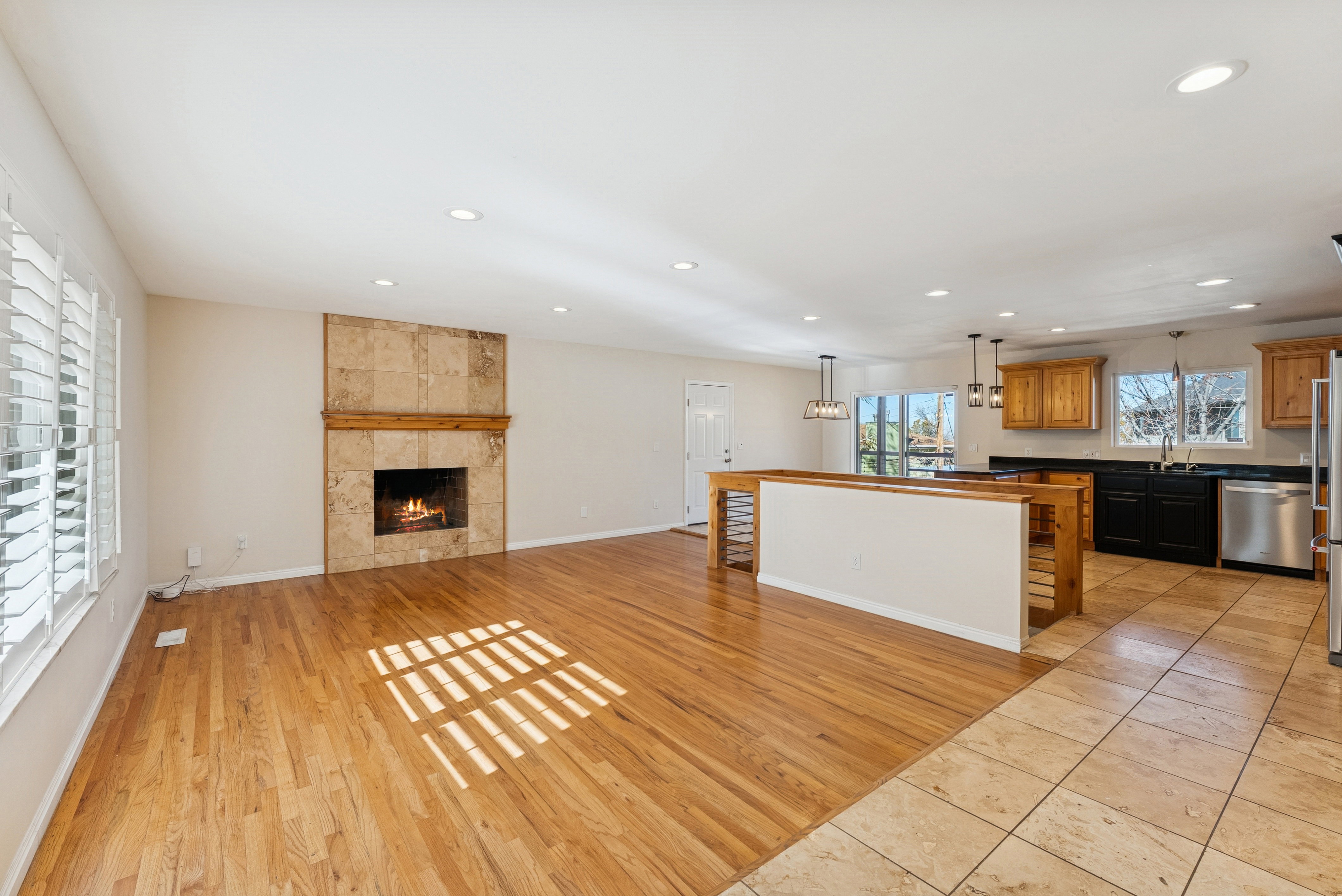 Unfurnished living room featuring light wood-style floors, recessed lighting, and a tiled fireplace