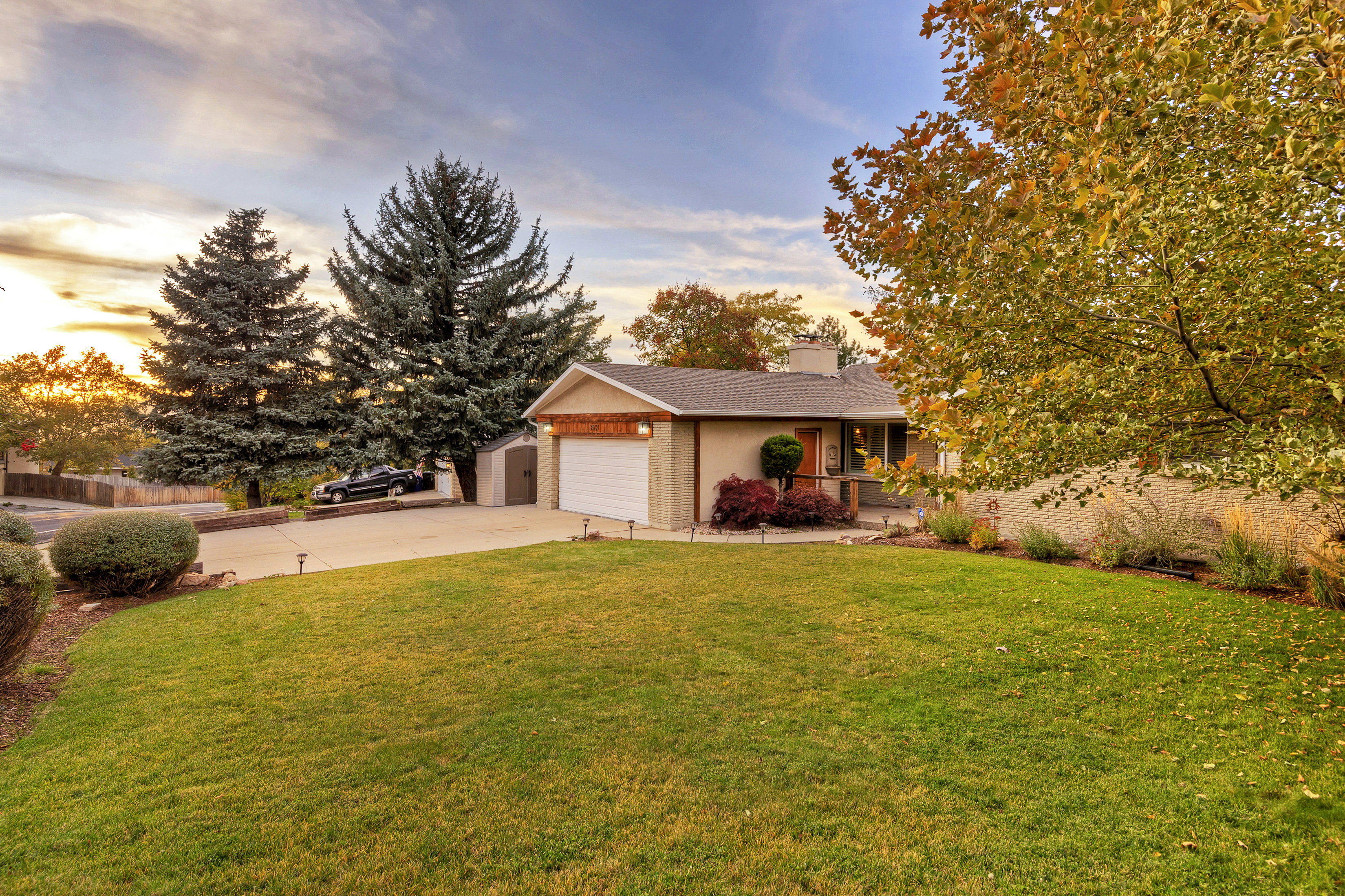 View of front of home featuring concrete driveway, brick siding, an attached garage, and a chimney