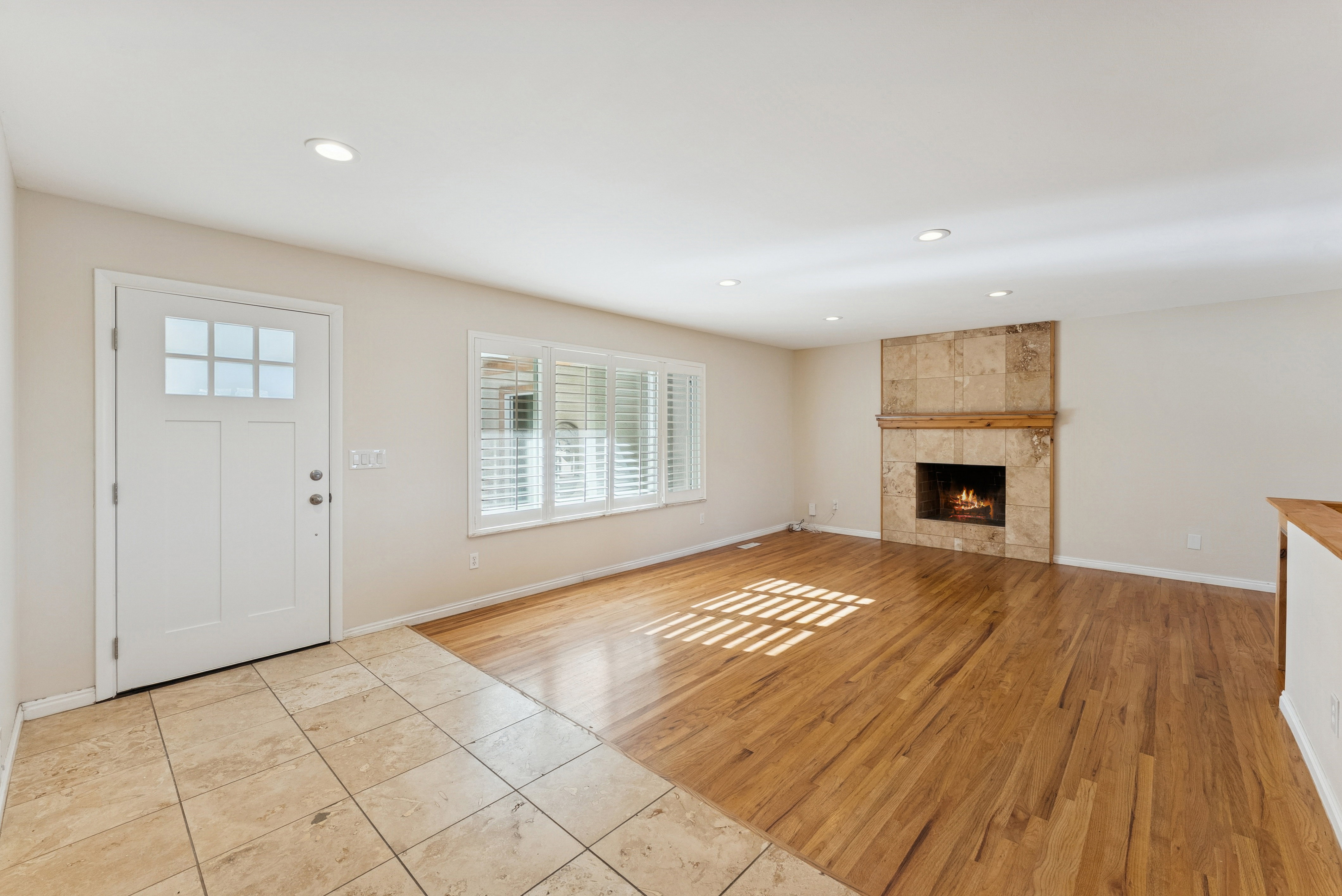 Entryway with light wood-type flooring, a tiled fireplace, and recessed lighting