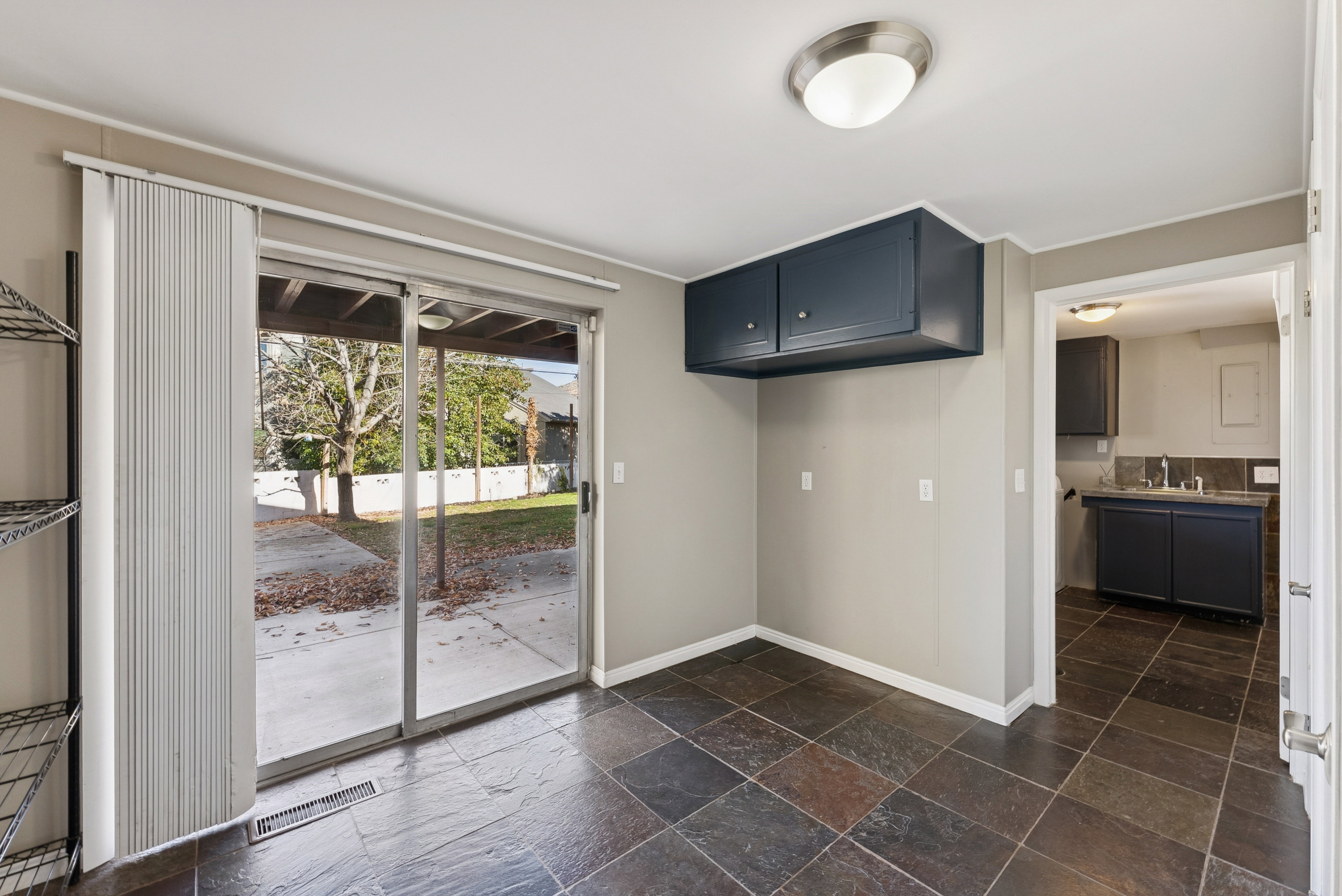 Kitchen featuring stone tile flooring, light countertops, and dark cabinetry