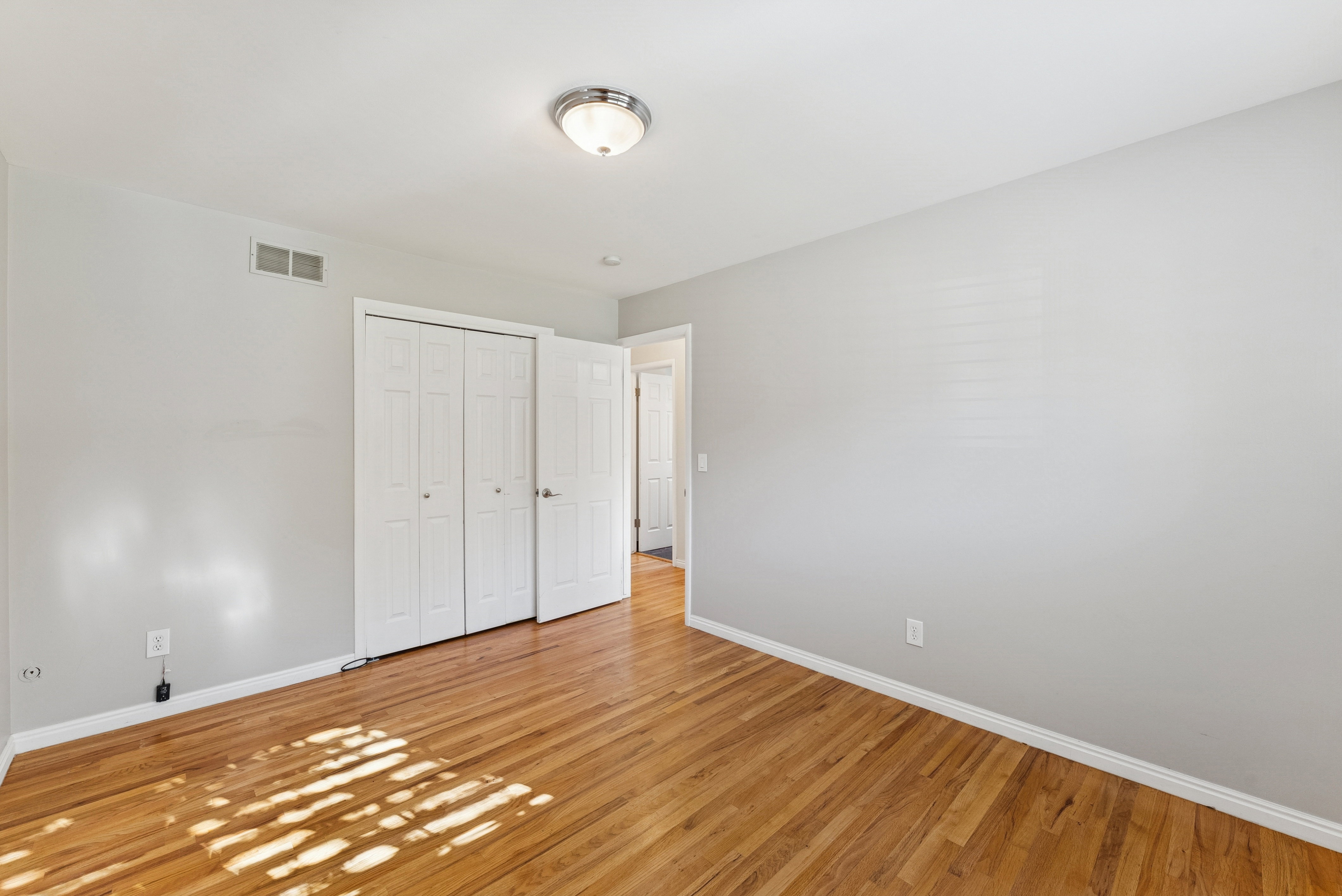 Unfurnished bedroom with a closet and light wood-style flooring