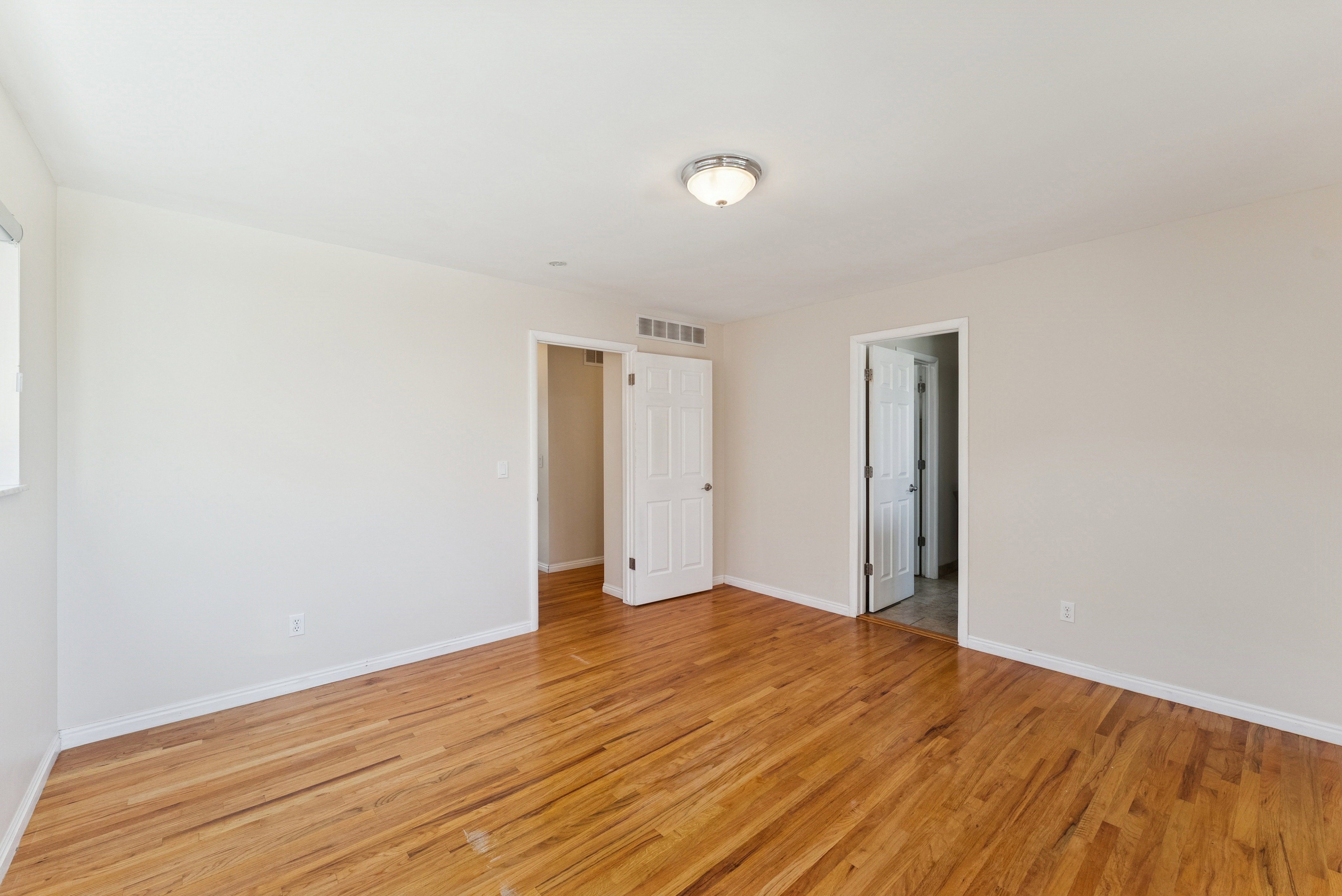 Unfurnished bedroom featuring light wood-type flooring and baseboards