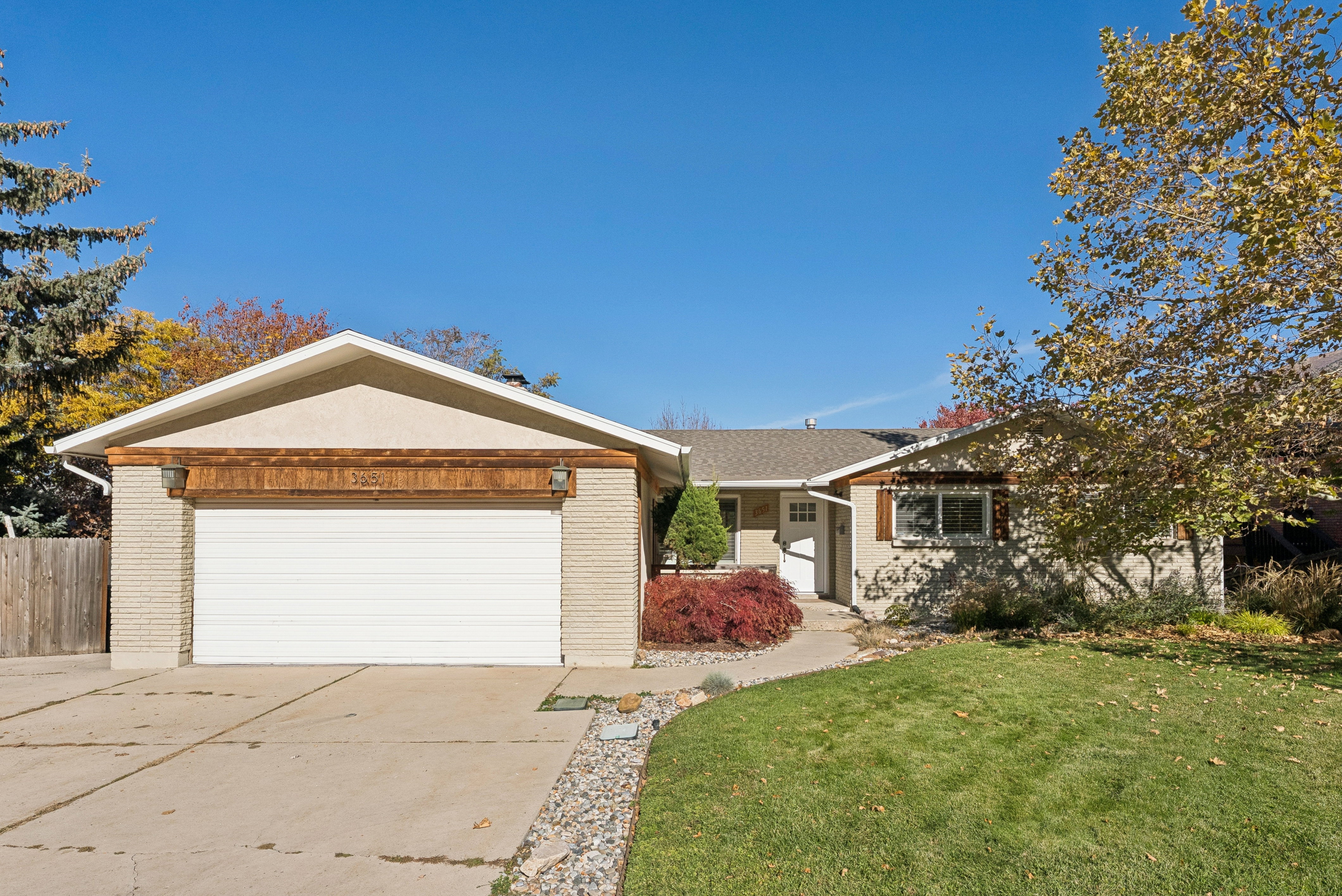 Single story home with brick siding, driveway, and an attached garage