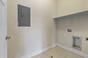 Laundry area with electric panel, tile patterned floors, washer hookup, and electric dryer hookup