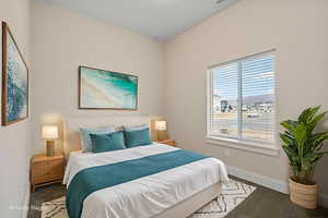 Bedroom with baseboards and dark colored carpet