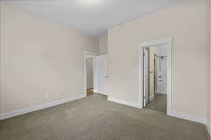 Unfurnished bedroom featuring carpet flooring and connected bathroom