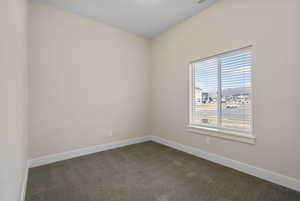 Empty room with dark carpet and baseboards