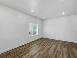 Empty room featuring dark wood-style flooring and recessed lighting