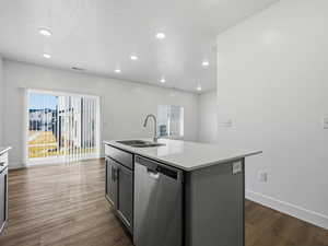 Kitchen featuring dishwasher, a center island with sink, dark wood-style flooring, light stone counters, and recessed lighting