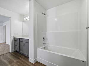 Full bath featuring shower / washtub combination, vanity, dark wood-style floors, and a textured ceiling