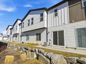 Back of property with board and batten siding and a patio area