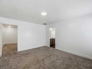 Carpeted empty room with baseboards
