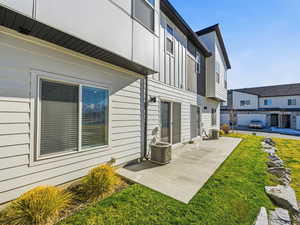 Back of property featuring a patio area, board and batten siding, and a lawn