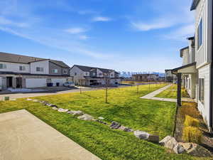 View of green lawn with a residential view and a mountain view