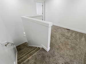 Staircase featuring carpet floors and baseboards