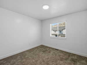 Unfurnished room featuring baseboards and carpet
