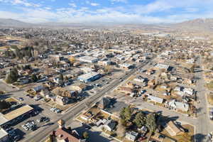 Aerial view of property and surrounding area featuring a mountainous background and nearby suburban area
