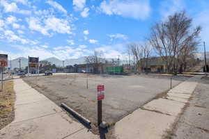 View of asphalt street with sidewalks, traffic signs, and a mountain view