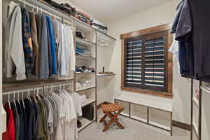 Master walk-in closet featuring light carpet