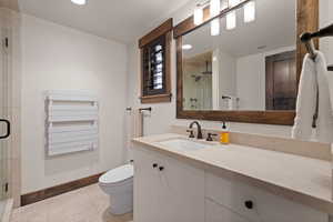 Full bath with radiator heating unit, vanity, a stall shower, light tile patterned floors, and recessed lighting
