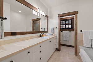 Full bath with vanity, a bath, light tile patterned flooring, and a shower with door