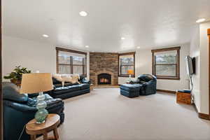 Carpeted living area with recessed lighting and a brick fireplace