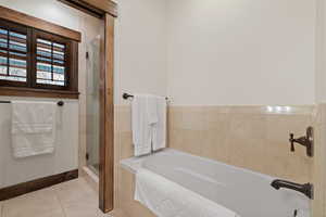 Bathroom featuring a garden tub, a stall shower, and tile patterned floors
