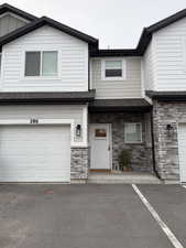 View of front of house with stone siding and a garage