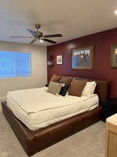 Carpeted bedroom featuring ceiling fan