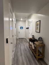 Doorway to outside with wood finished floors and baseboards