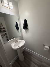 Half bath featuring dark wood-type flooring and baseboards