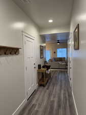 Corridor with dark wood-style floors and recessed lighting