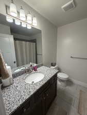 Full bath with a shower with shower curtain, vanity, light tile patterned floors, and a textured ceiling