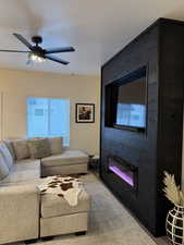 Living room featuring ceiling fan and a textured ceiling