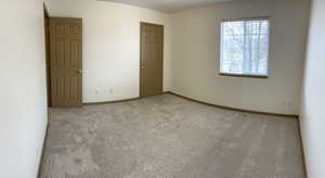 Unfurnished bedroom with carpet floors and baseboards