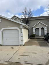 View of front of home with stucco siding and driveway