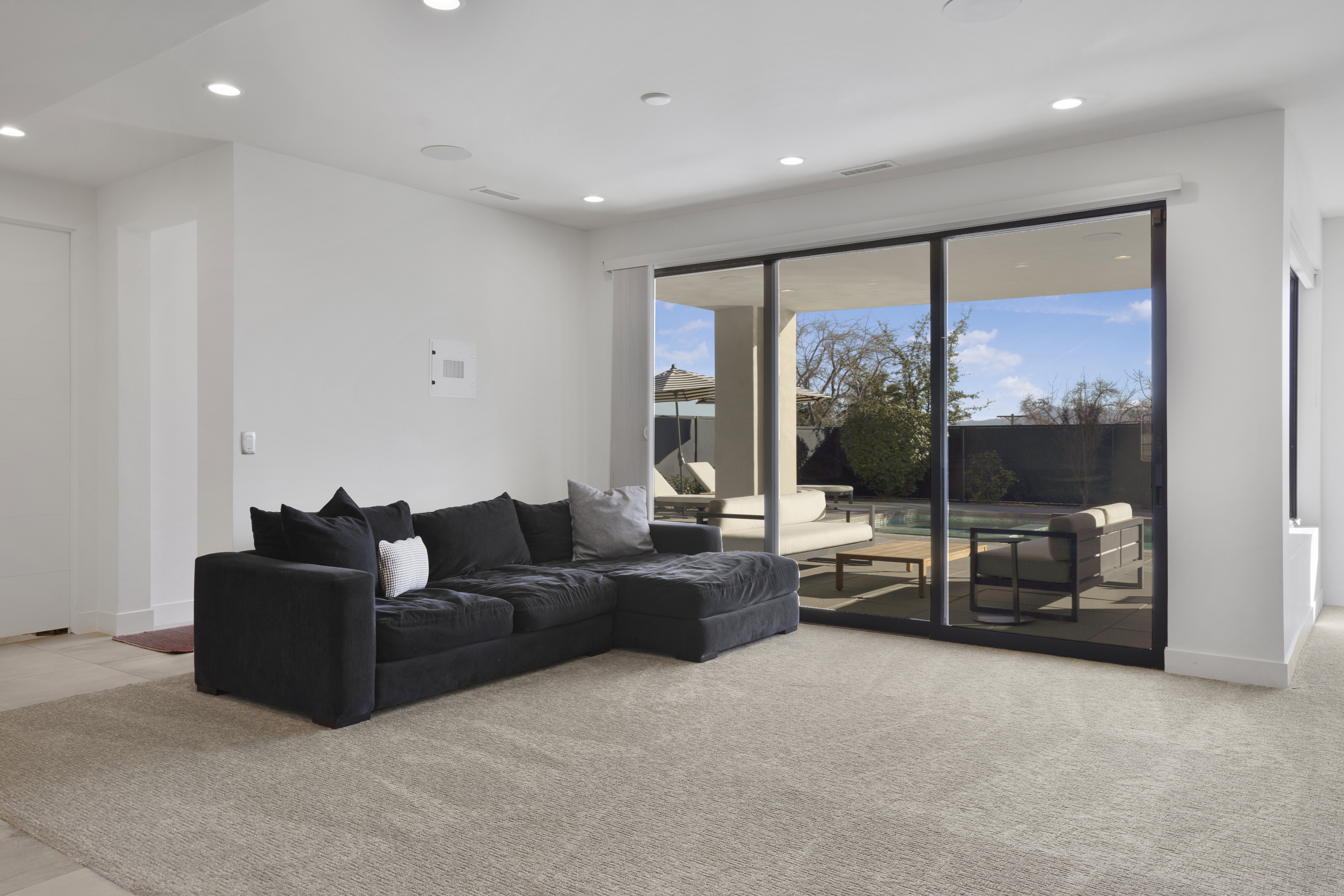 Living area with recessed lighting and light colored carpet