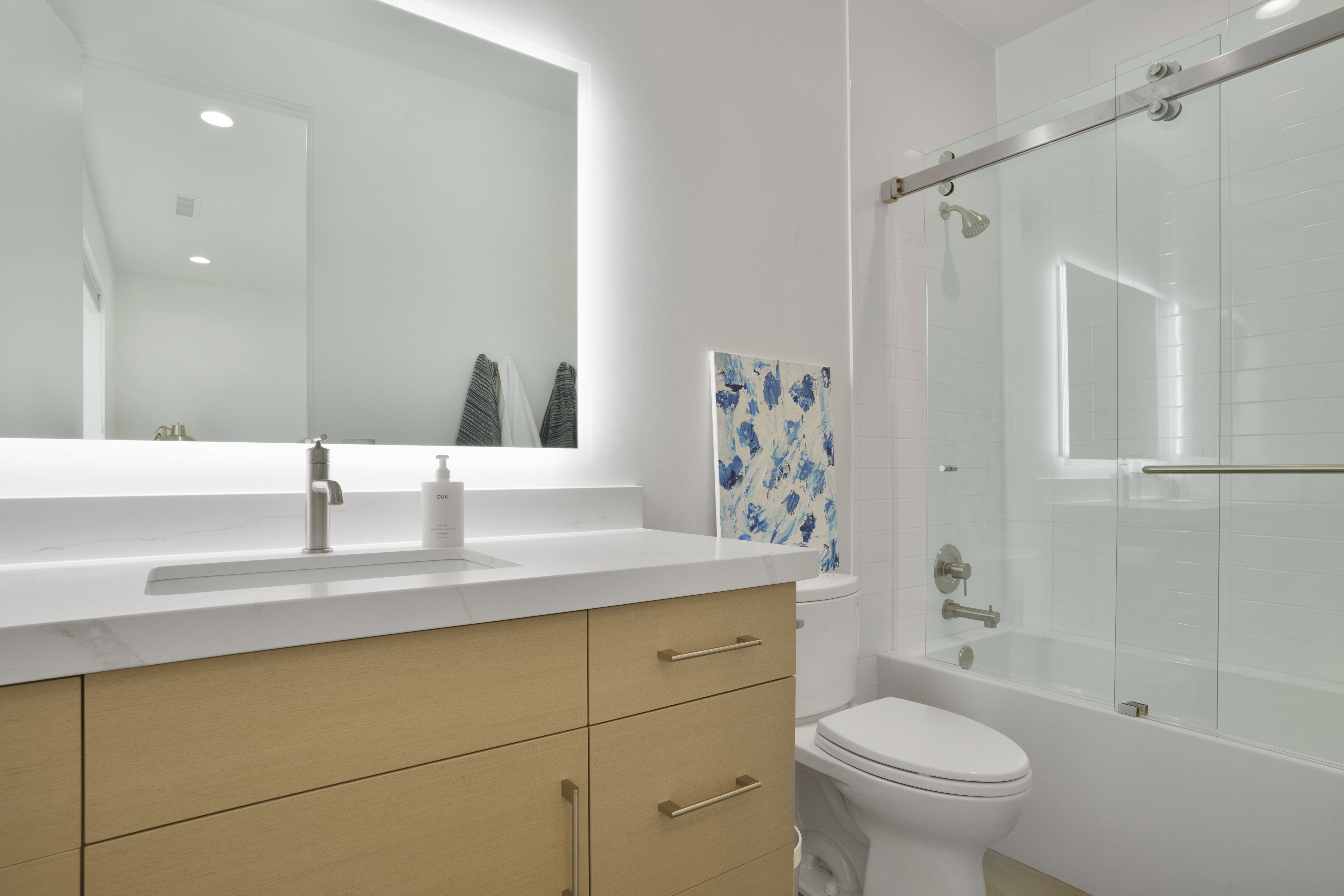 Bathroom featuring vanity, shower / bath combination with glass door, and recessed lighting