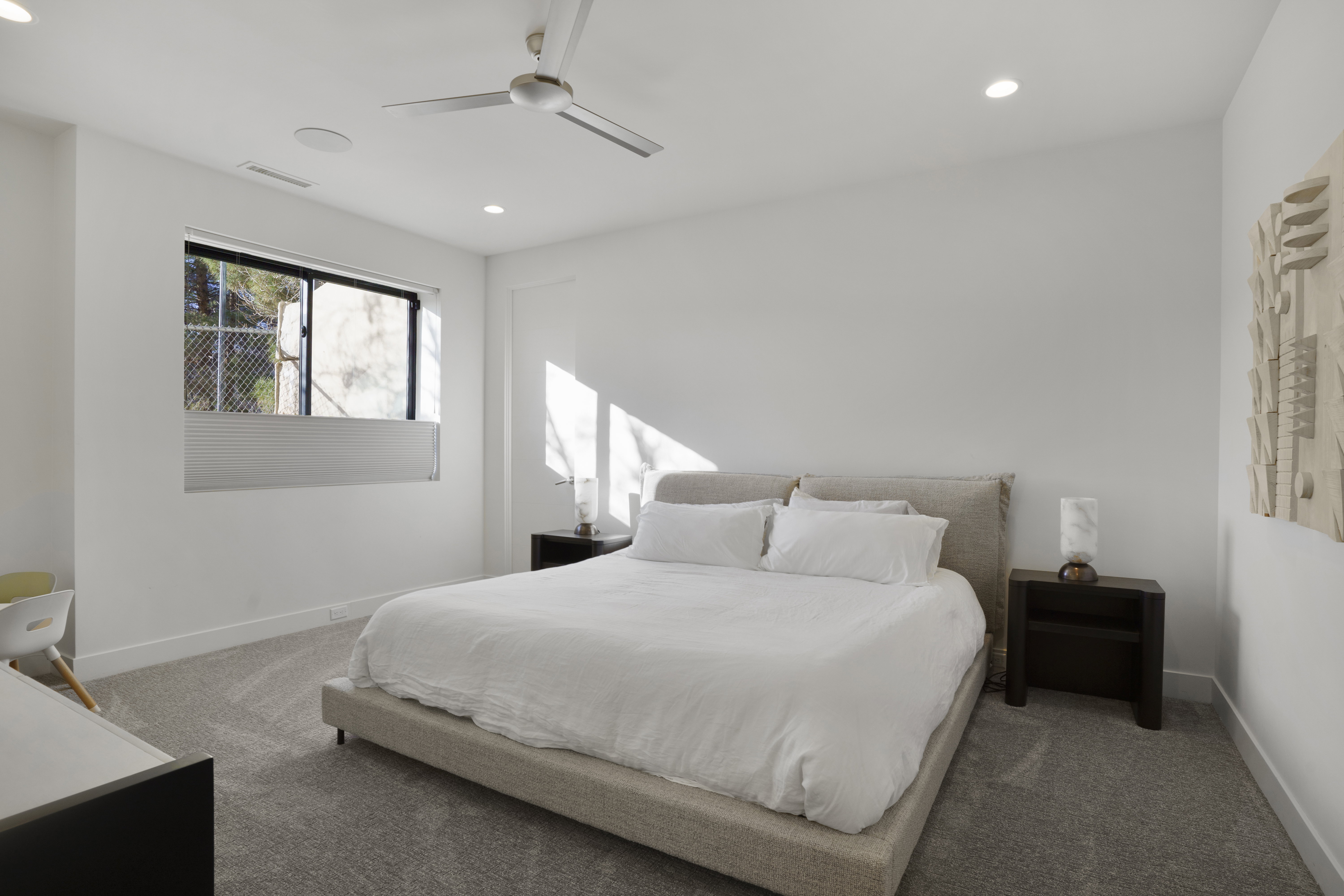 Carpeted bedroom with a ceiling fan and recessed lighting