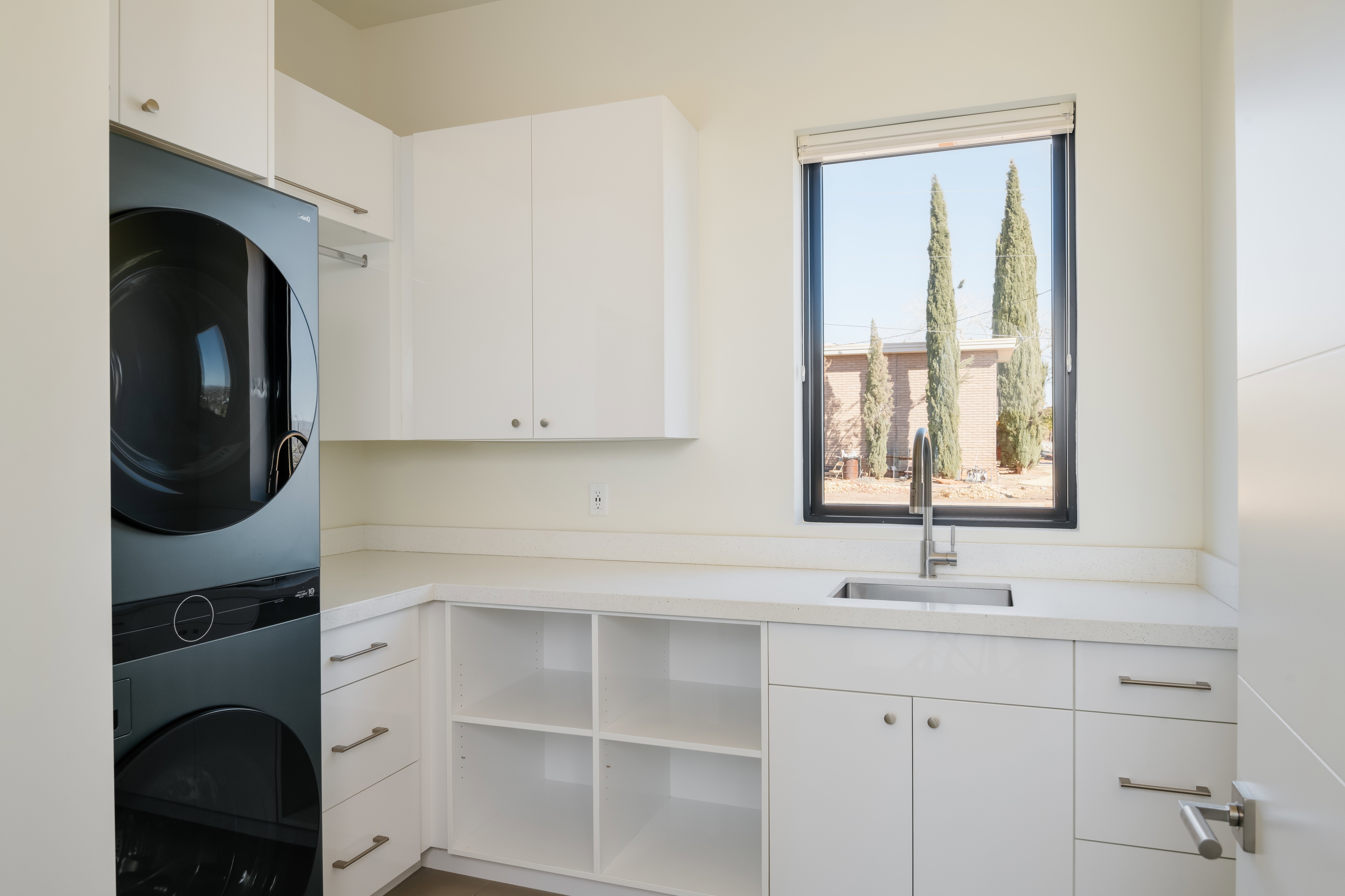 Laundry room featuring cabinet space and stacked washer / drying machine