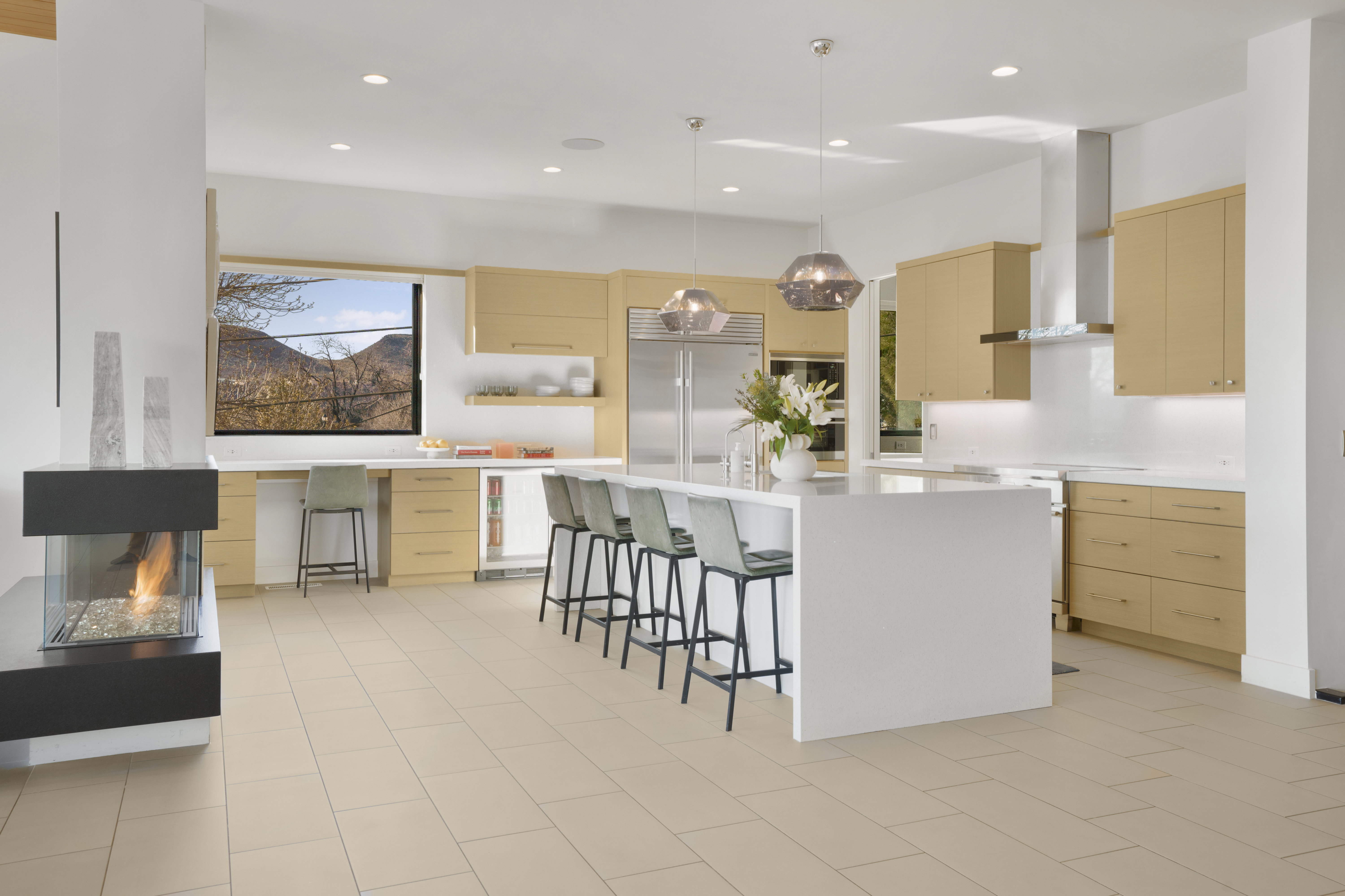 Kitchen with a kitchen bar, built in refrigerator, hanging light fixtures, open shelves, and modern cabinets