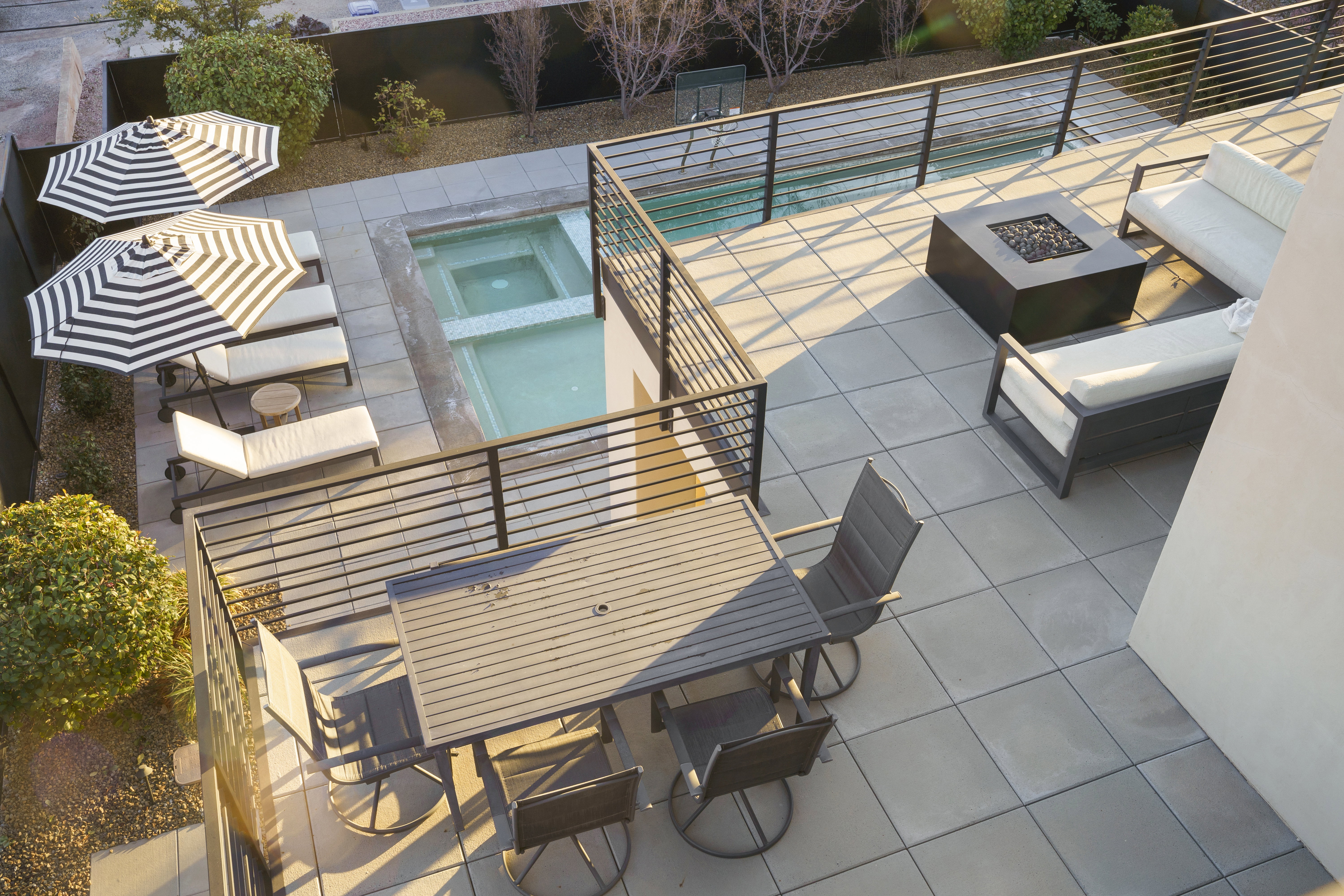 View of patio featuring a fire pit, outdoor dining area, and a pool with connected hot tub
