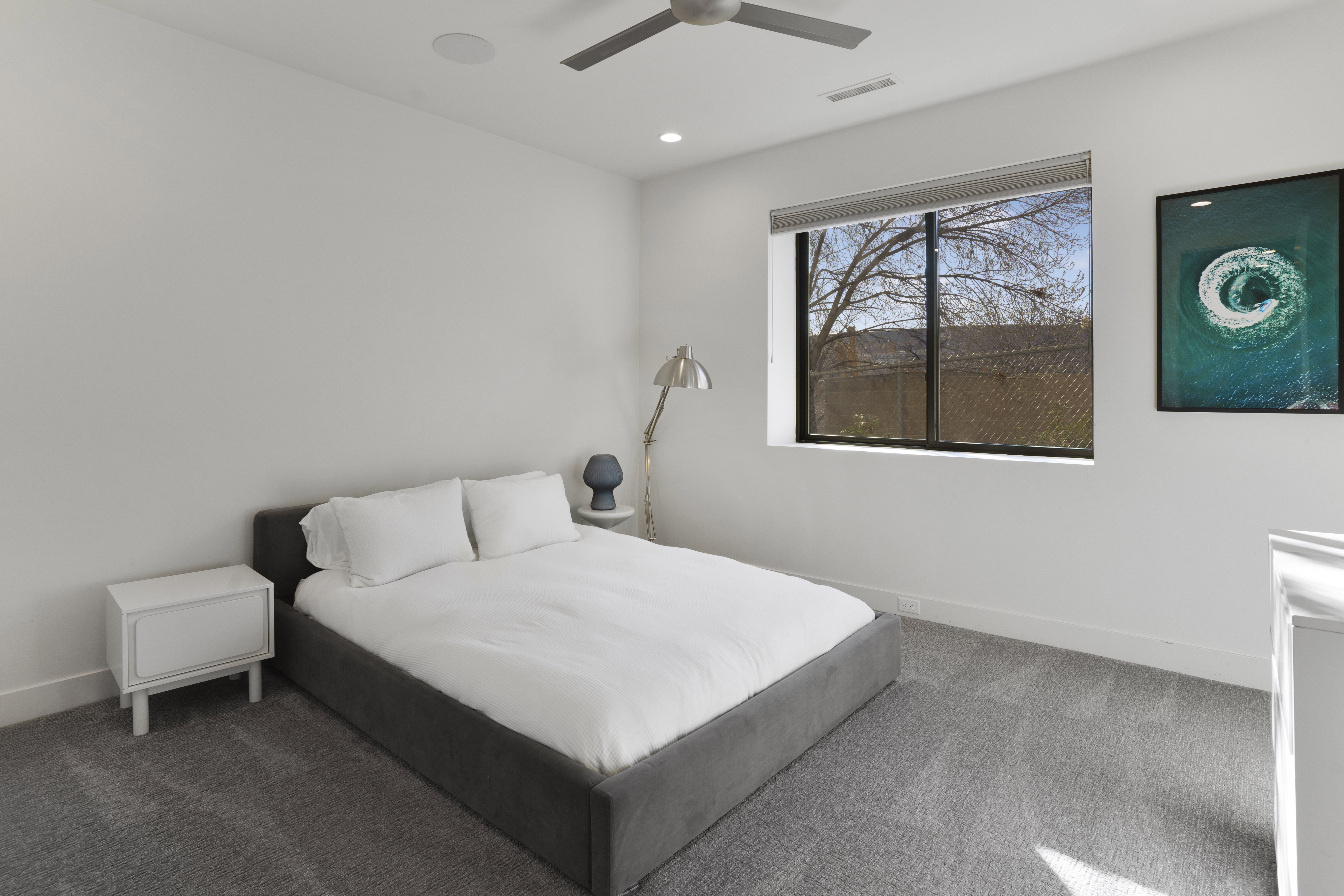 Carpeted bedroom featuring ceiling fan and recessed lighting