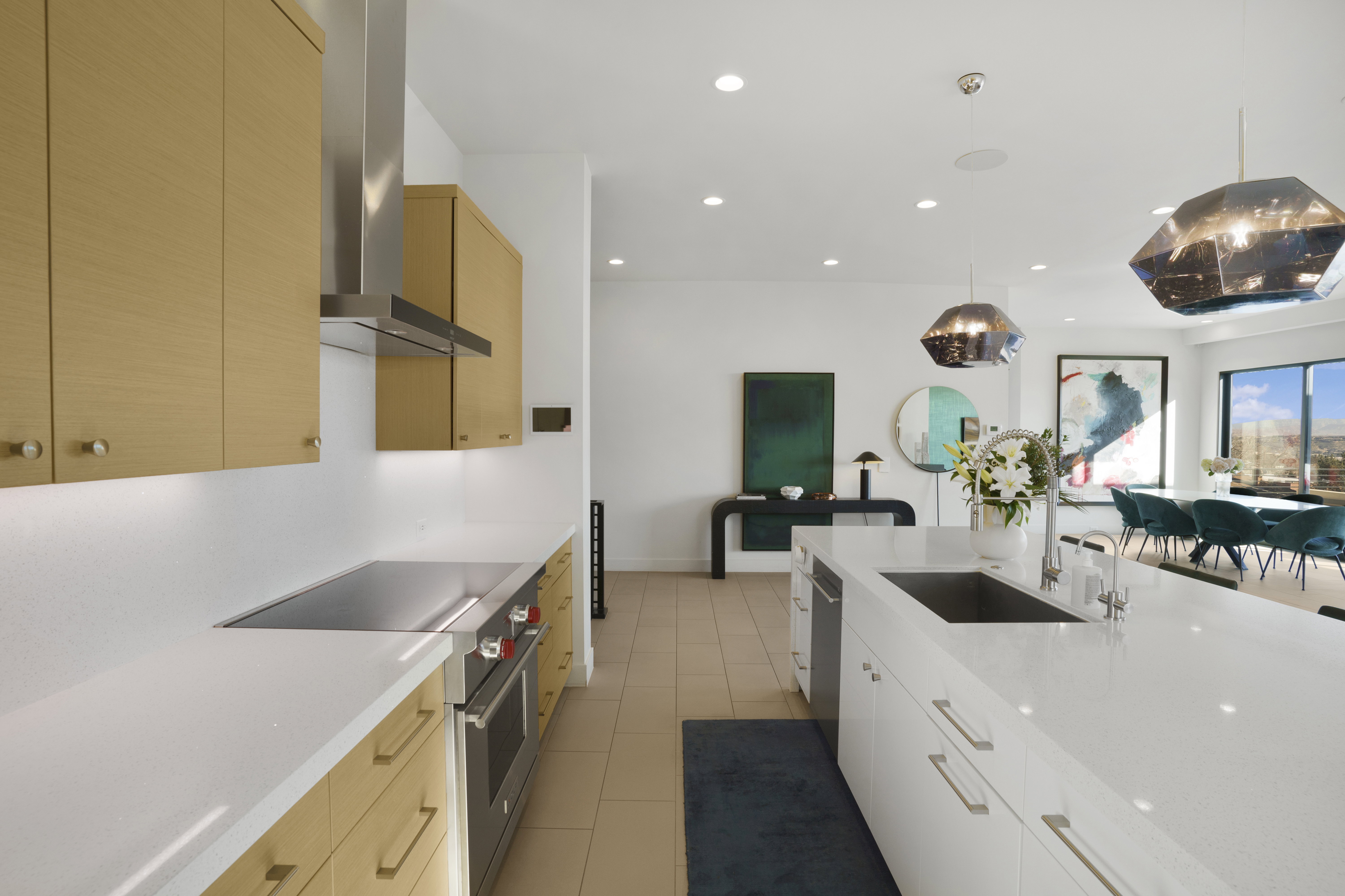 Kitchen with stainless steel appliances, hanging light fixtures, light stone countertops, and light wood finish cabinetry